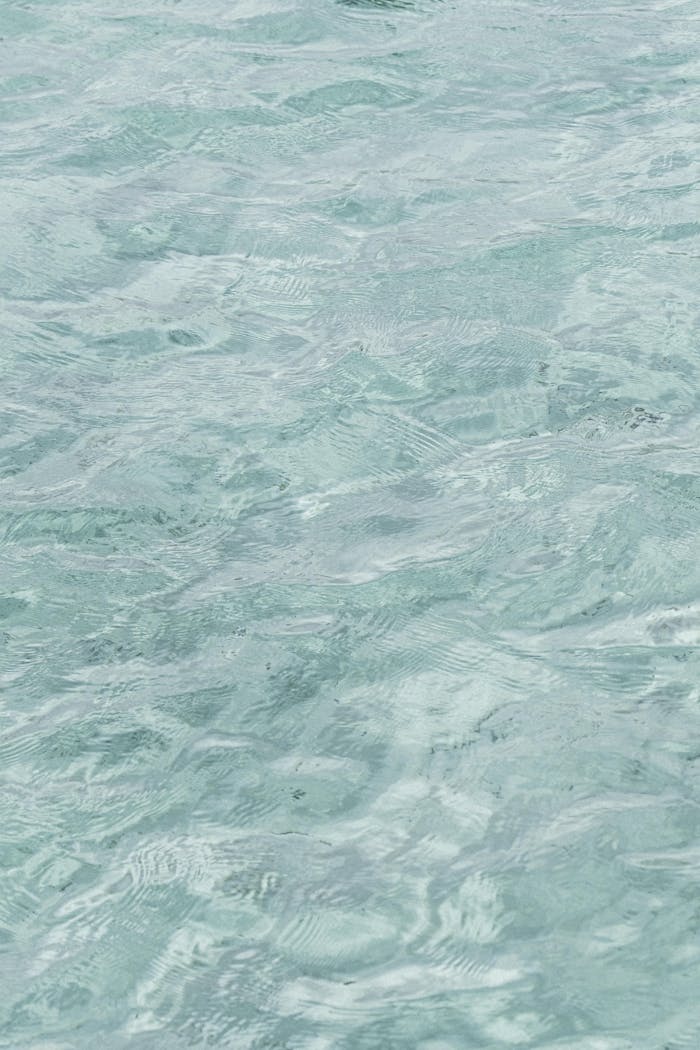 Serene and clear aqua pool surface showcasing gentle ripples, ideal for a tranquil background.